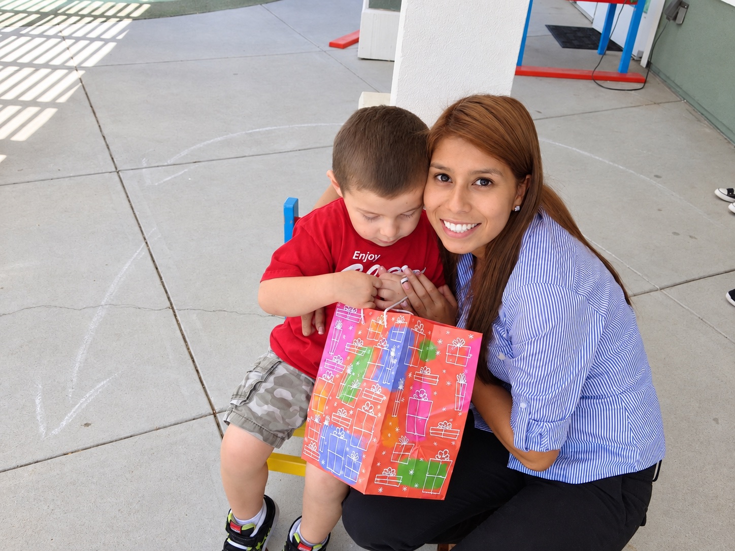 A smiling adult and child sharing a celebration at Kinder Casa